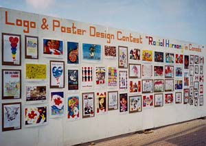 Photo of wall with logo and posters from design contest.